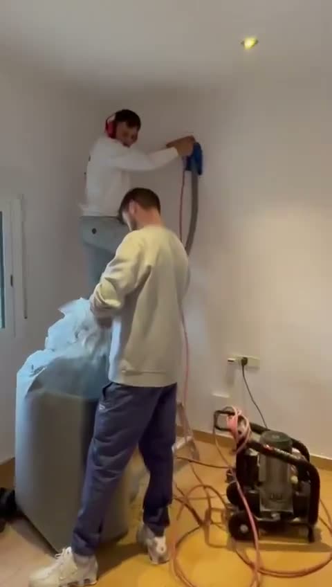 Operario insuflando aislamiento por los taladros de una pared